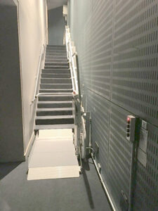 Wheelchair Lift waiting at the bottom of a flight of stairs